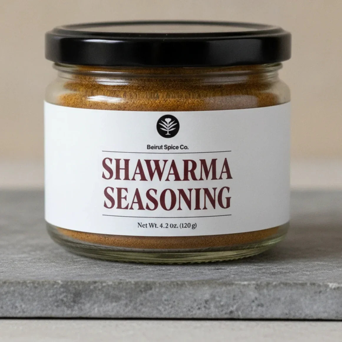 Lebanese shawarma seasoning in a Beirut Spice Co jar on a stone slab.