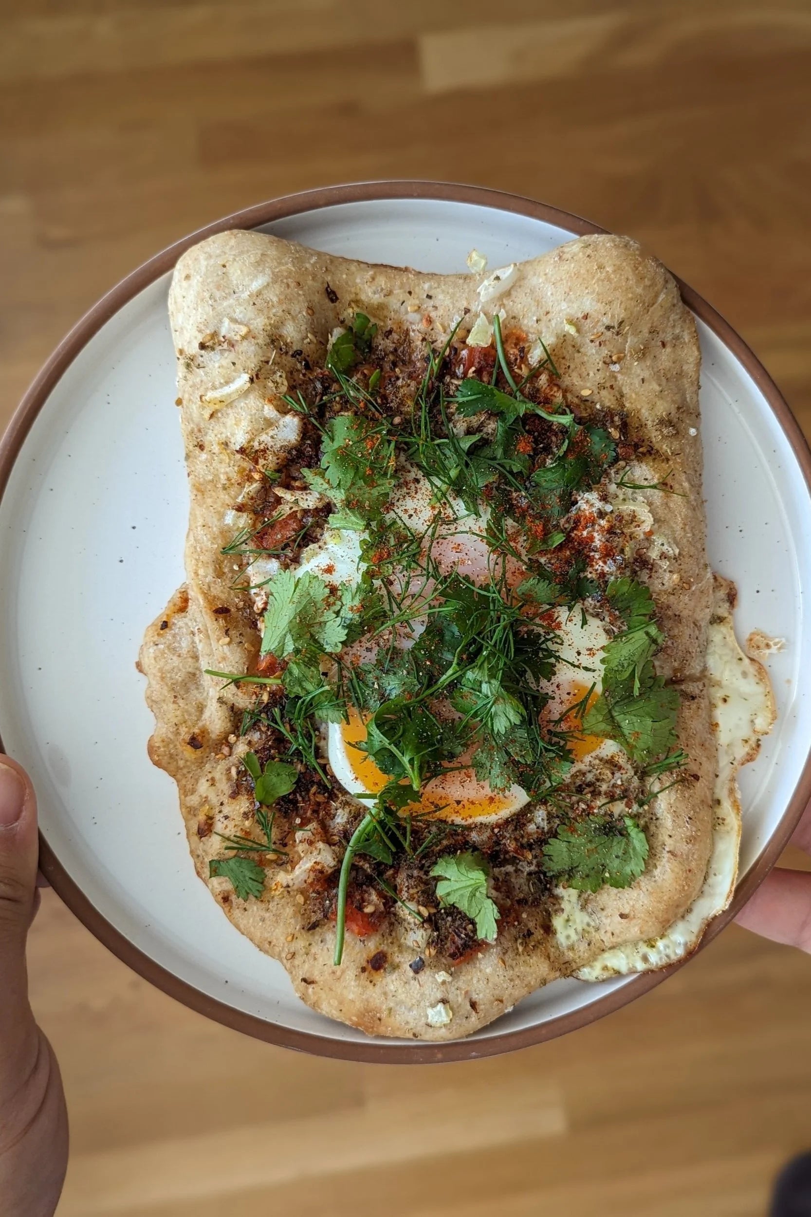 Za’atar flatbread topped with eggs and fresh herbs